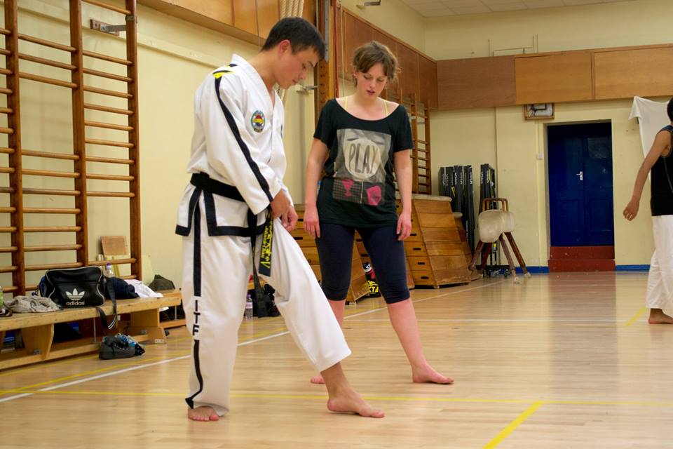 Mr Chan teaching Taekwon-Do to new students. Student watches as he is pointing to his foot.
